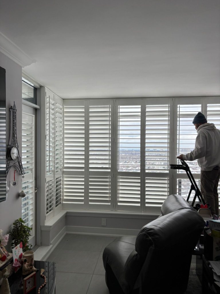 Shutter Outlet specialist setting up smart motorized blinds for a homeowner