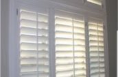 Arched custom shutters with a white finish, providing light control and a sleek design for windows in Barrie, available at Shutter Outlet.